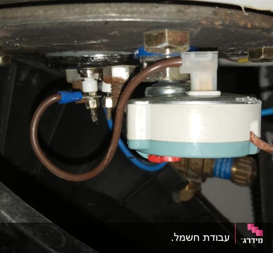 חוטים מחוברים לרכיב חשמלי עם ברגים